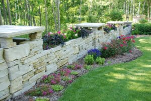Stone wall with colorful plants.