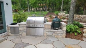 Stone back porch with stone wall and grill built in.